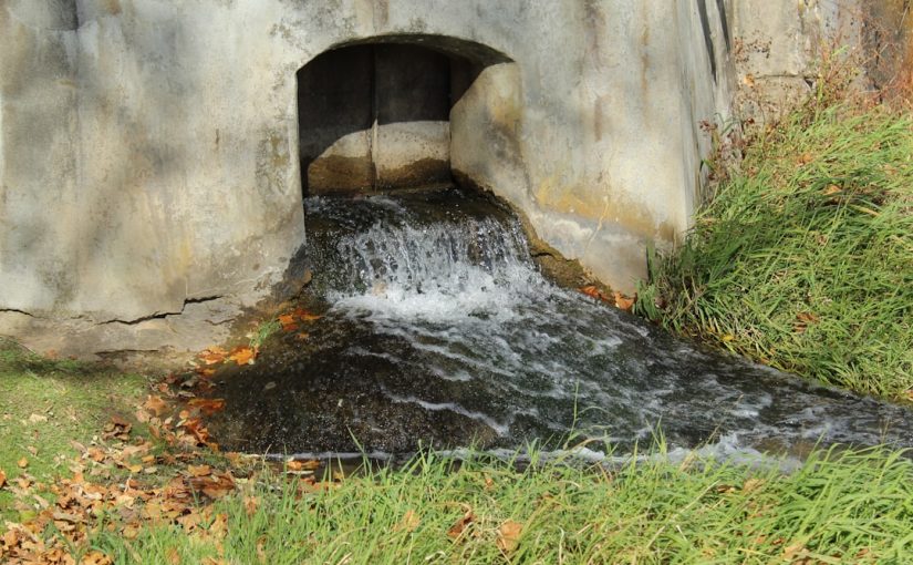 a small waterfall in a stone tunnel
