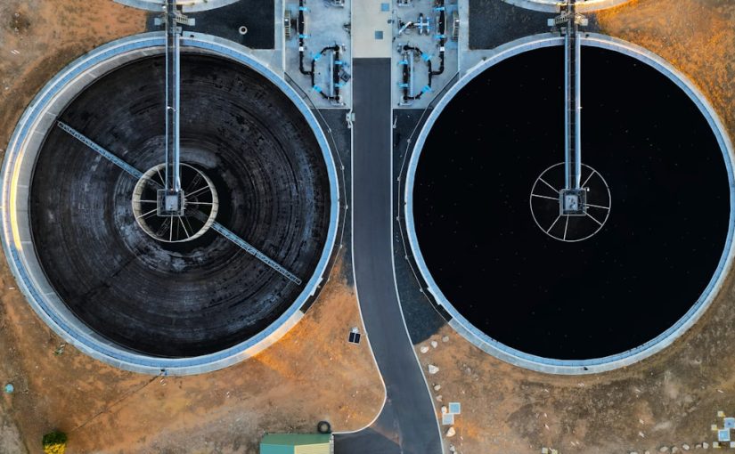 an aerial view of two large black tanks